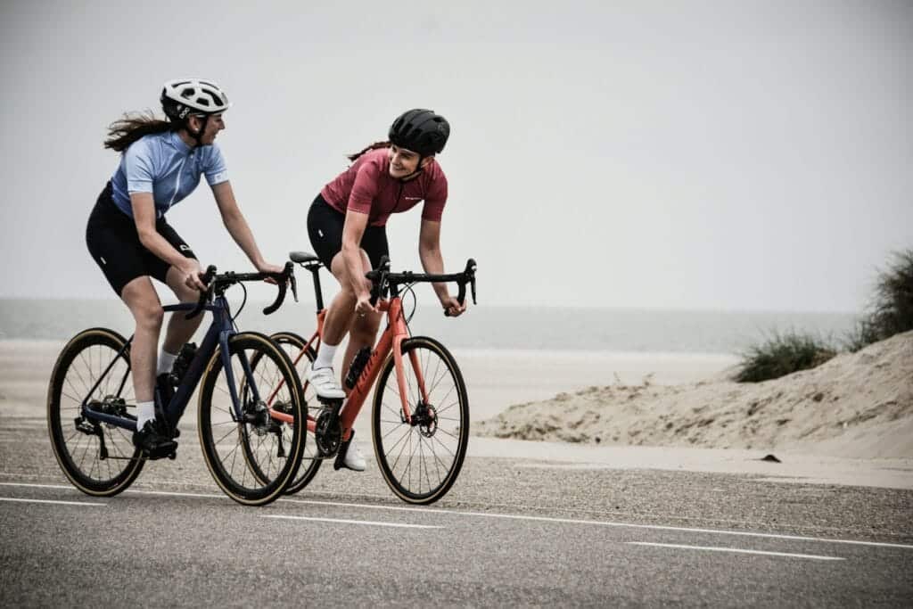 man and woman riding road bikes at the road near shore Good Exercises to Lose Weight